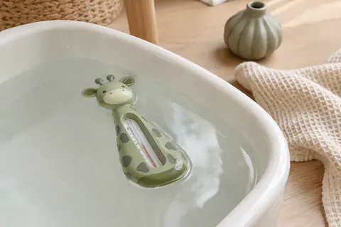 Thermomètre de bain flottant vert en forme de girafe avec échelle analogique transparente.
