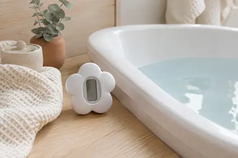 Thermomètre de bain numérique blanc à forme de pétales flottant à la surface de l’eau